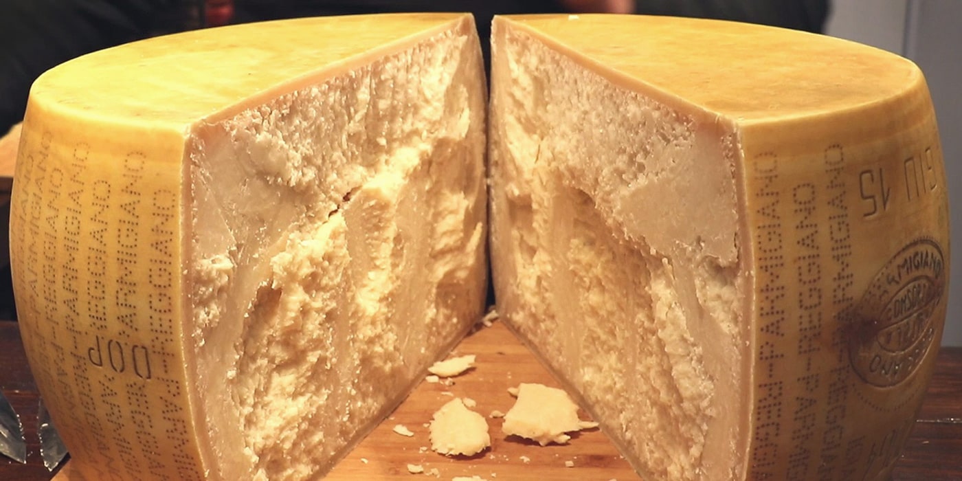 Разрезанная пополам головка твёрдого сыра Пармезан